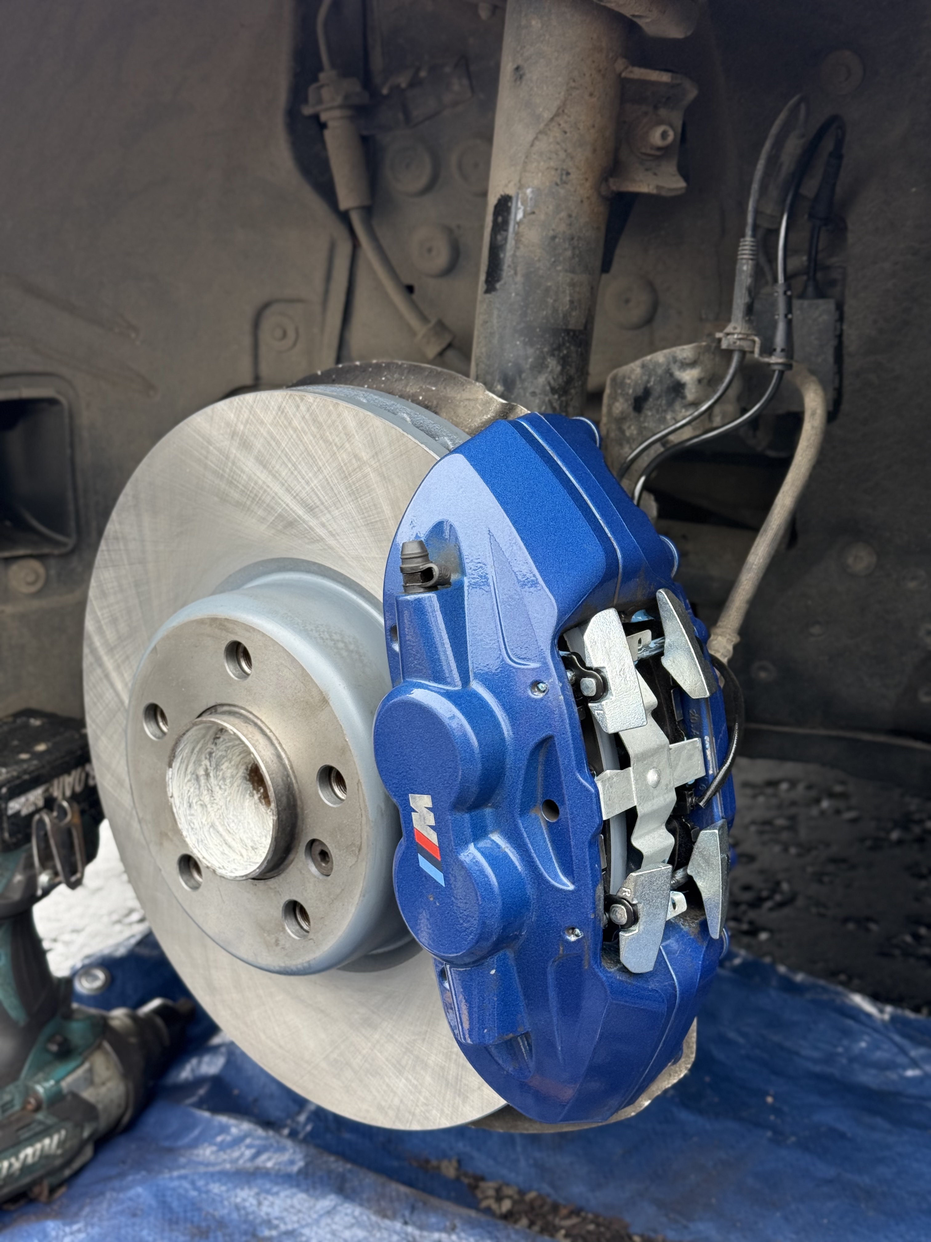 Brake disc and blue brake caliper during vehicle brake servicing