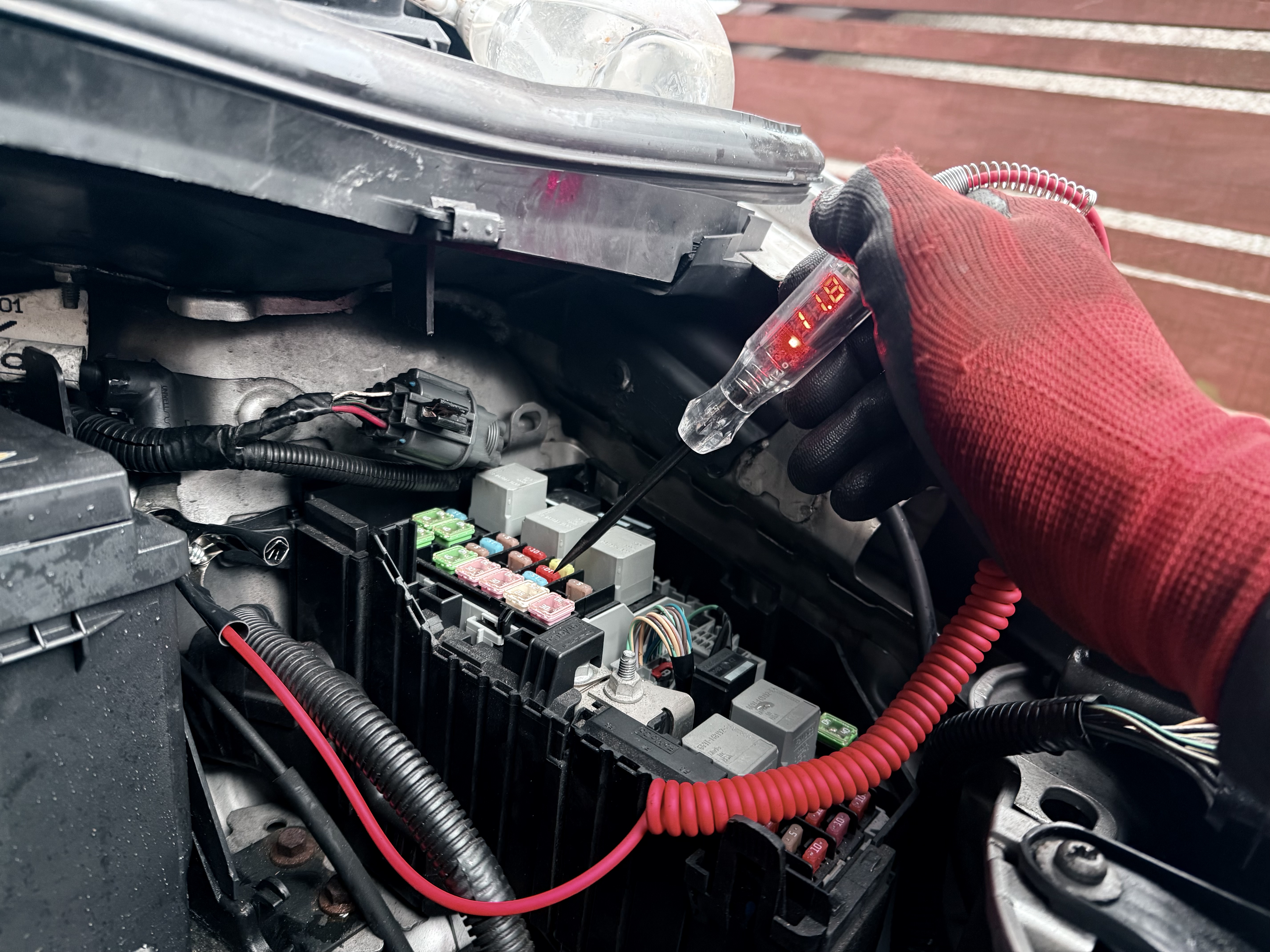 Electrical testing with a voltage probe at a vehicle fuse and relay box